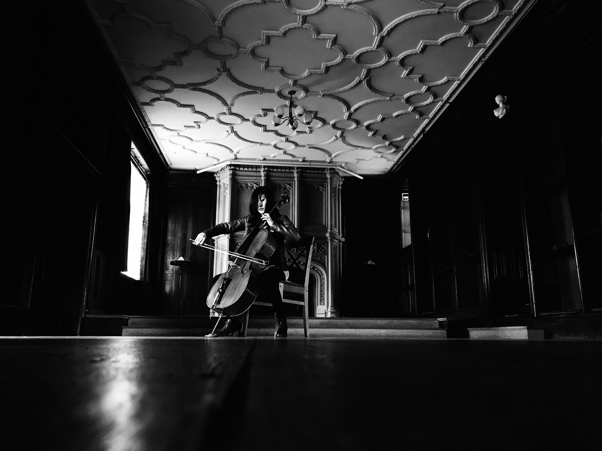 a woman plays a cello in an empty room